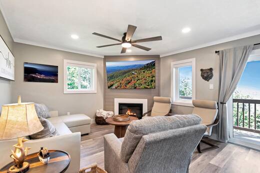 Living room seating around the fireplace with mountain views