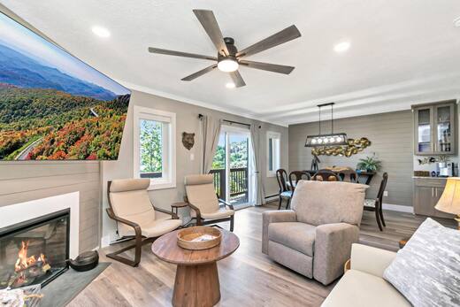 Two-bedroom condo living room with lit gas fireplace and dining area beyond