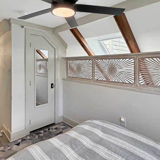 Bedroom viewed from the rear showing carved sunburst screens and a skylight